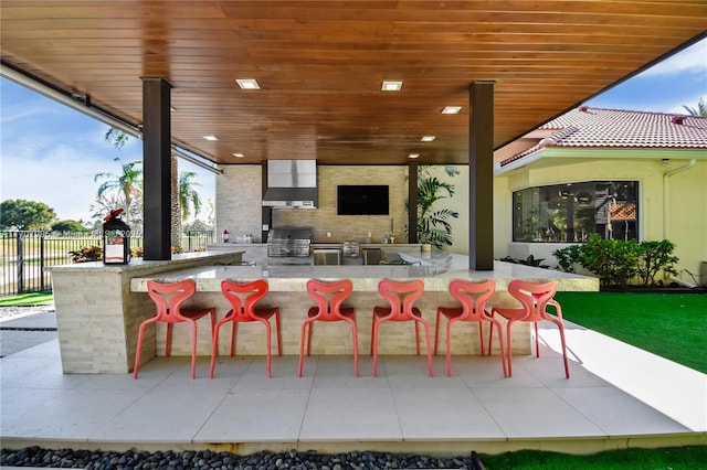 view of patio / terrace featuring a bar, area for grilling, and exterior kitchen