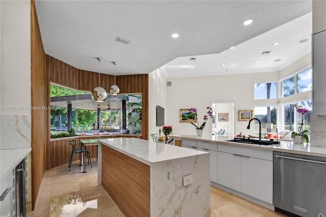 kitchen with sink, white cabinetry, decorative light fixtures, a center island, and stainless steel dishwasher