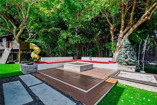 2445 Provence Cir, Weston, FL 33327 - surrounding community featuring a trampoline, a yard, an outdoor living space with a fire pit, and a deck