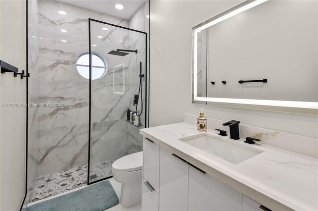 bathroom with vanity, wood walls, toilet, and a shower with shower door