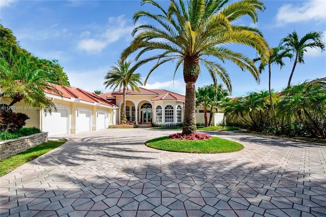 2445 Provence Cir, Weston, FL 33327 - mediterranean / spanish house with curved driveway, a garage, stucco siding, and fence