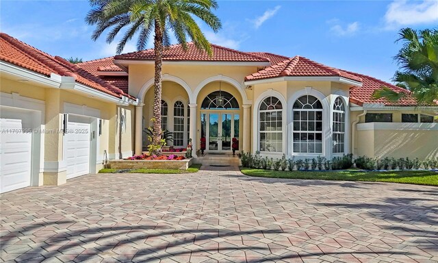 2445 Provence Cir, Weston, FL 33327 - back of property with an attached garage, decorative driveway, french doors, and a tiled roof