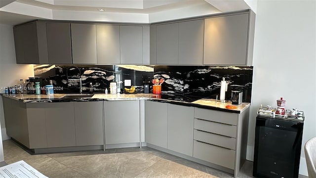 kitchen featuring gray cabinetry, black electric stovetop, sink, dark stone countertops, and light tile patterned floors