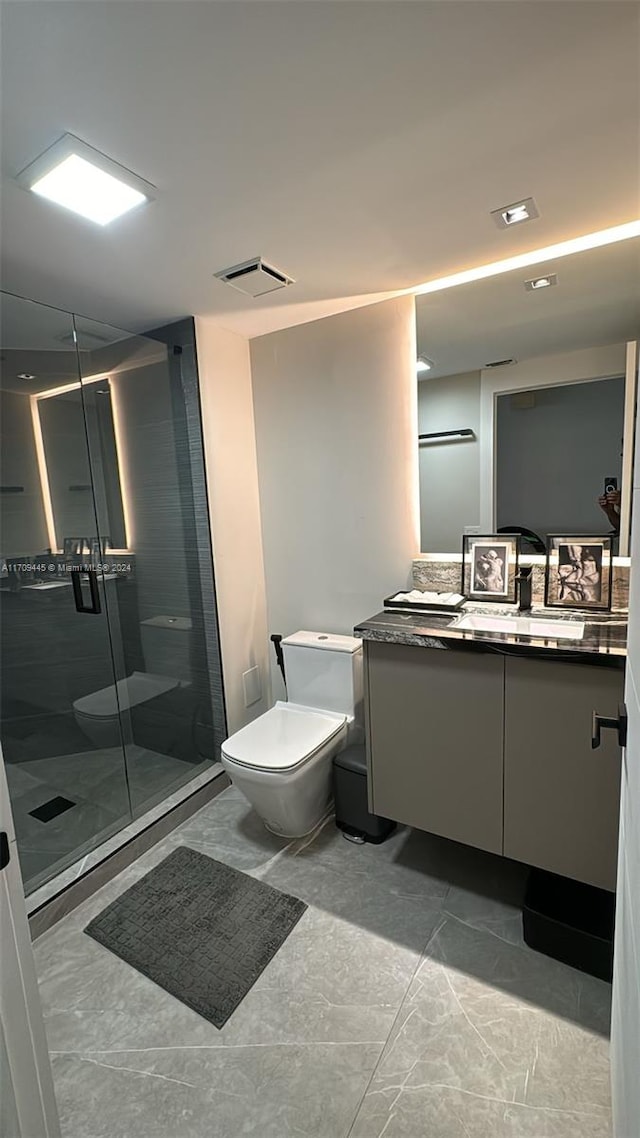 bathroom with vanity, toilet, and an enclosed shower