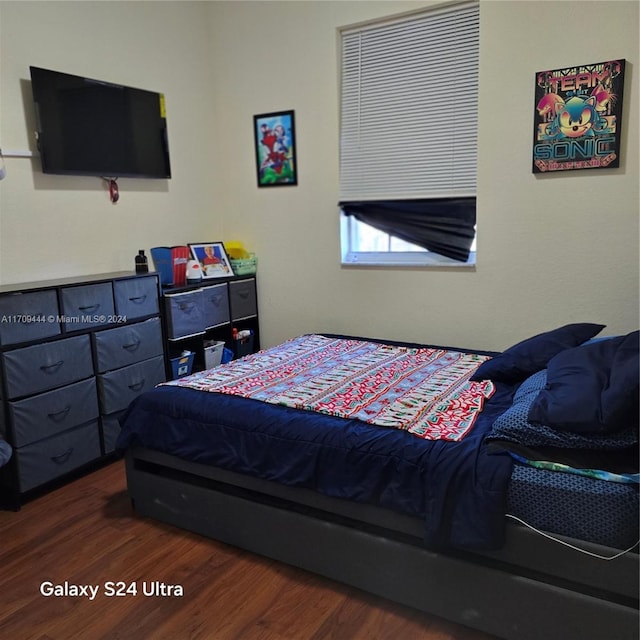 bedroom with dark hardwood / wood-style floors