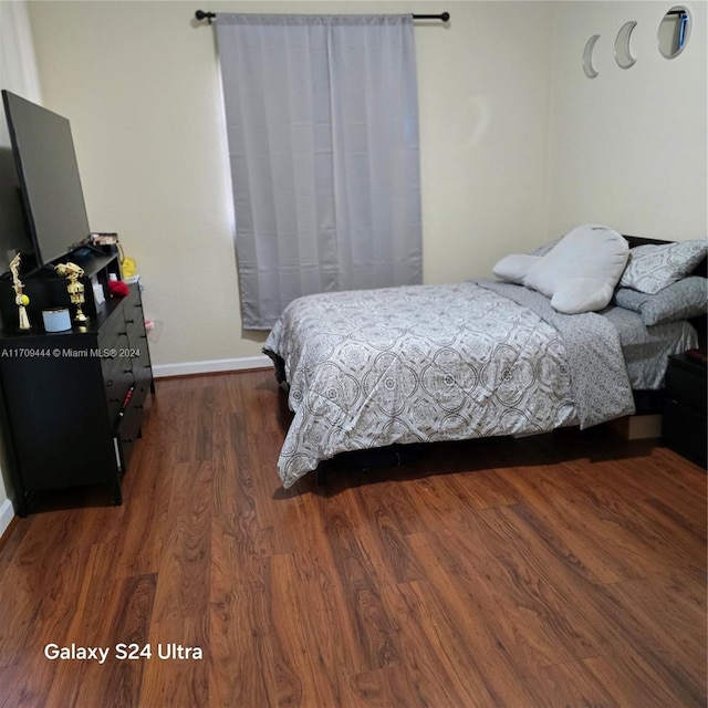 bedroom with dark wood-type flooring