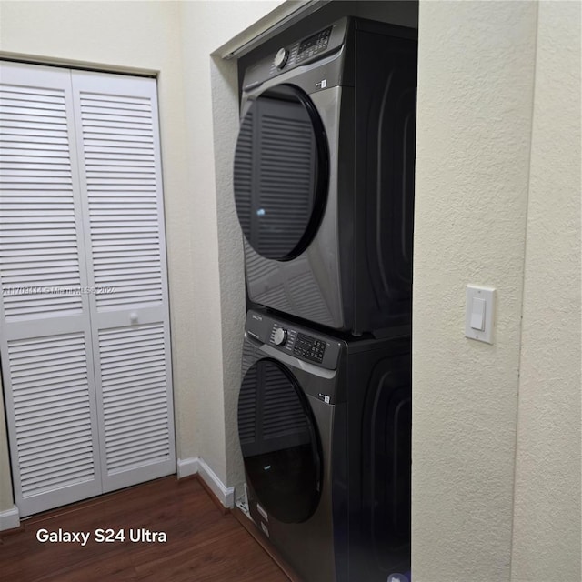 laundry area with dark hardwood / wood-style flooring and stacked washer / drying machine