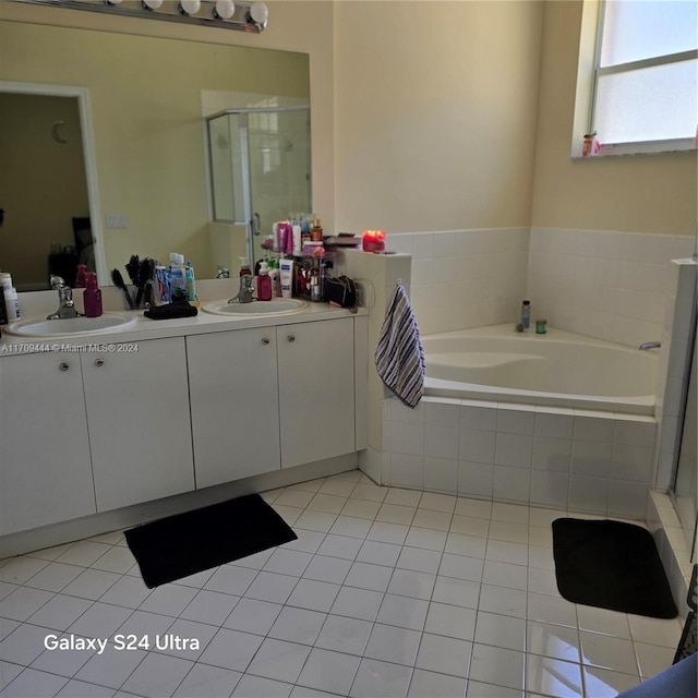 bathroom with tile patterned floors, vanity, and shower with separate bathtub