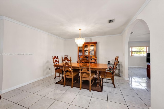 tiled dining space featuring a notable chandelier and ornamental molding