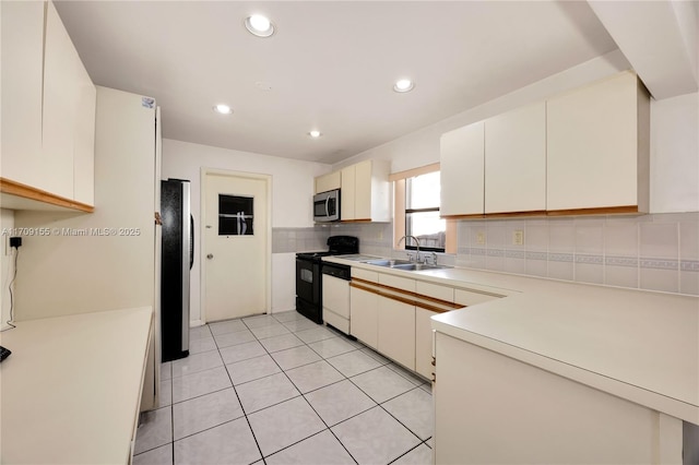 kitchen featuring white cabinets, sink, light tile patterned flooring, and appliances with stainless steel finishes