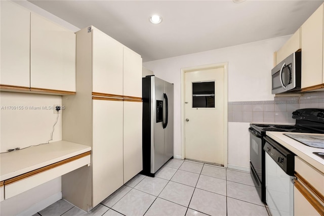 kitchen featuring appliances with stainless steel finishes, light tile patterned floors, tasteful backsplash, and white cabinetry