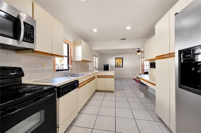 kitchen featuring kitchen peninsula, black range with electric cooktop, white dishwasher, ceiling fan, and sink