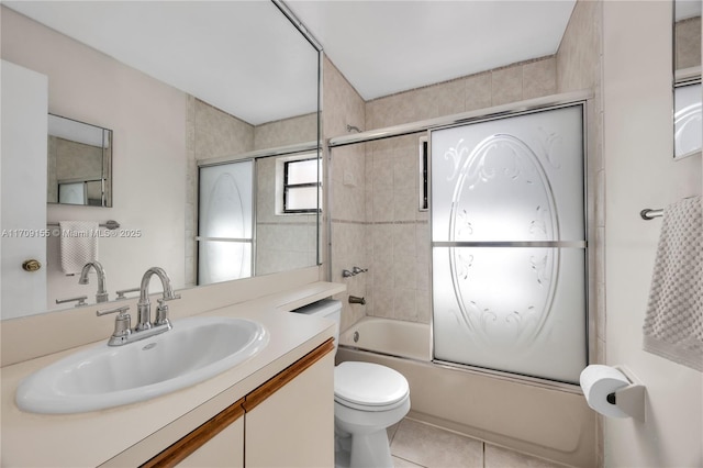 full bathroom with combined bath / shower with glass door, vanity, toilet, and tile patterned flooring