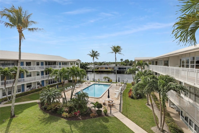 view of pool featuring a yard and a water view