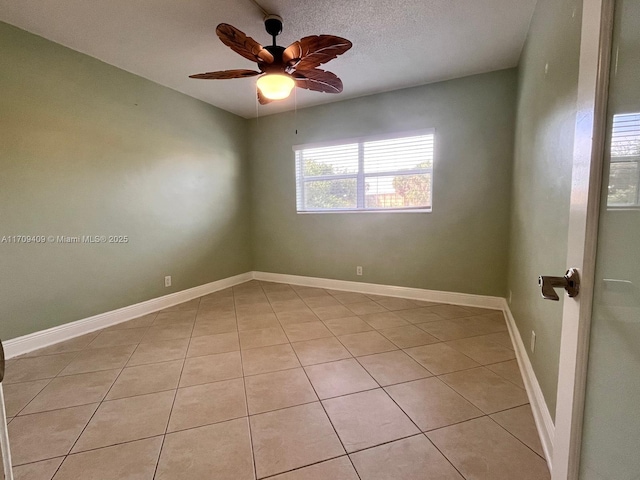 spare room with ceiling fan and light tile patterned floors