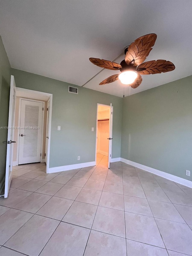 tiled empty room with ceiling fan