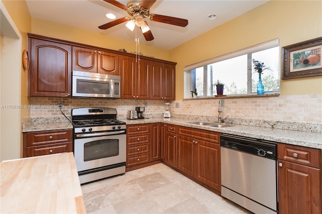 kitchen with backsplash, ceiling fan, sink, and appliances with stainless steel finishes