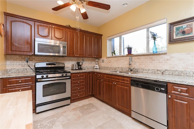 kitchen with backsplash, ceiling fan, sink, and appliances with stainless steel finishes