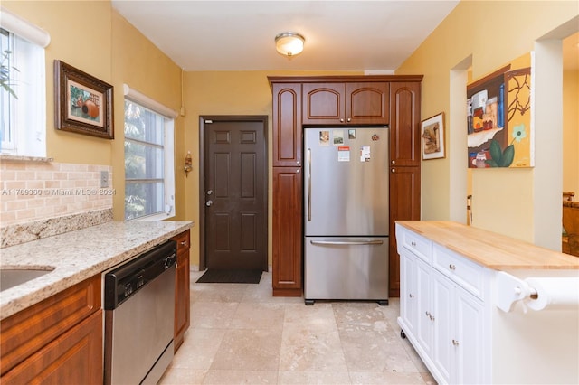 kitchen featuring appliances with stainless steel finishes, backsplash, butcher block countertops, and white cabinetry