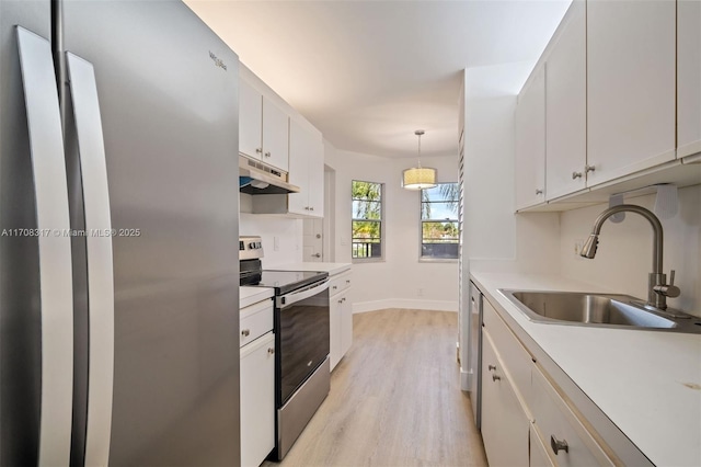 kitchen featuring appliances with stainless steel finishes, sink, decorative light fixtures, light hardwood / wood-style flooring, and white cabinets