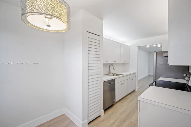 kitchen featuring light wood-type flooring, white cabinetry, sink, and appliances with stainless steel finishes