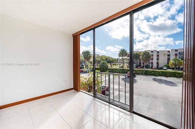 unfurnished room with plenty of natural light, floor to ceiling windows, and light tile patterned floors