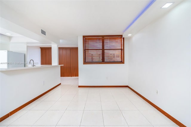 unfurnished room featuring sink and light tile patterned flooring