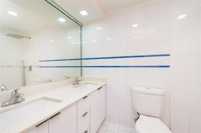 bathroom with tile patterned flooring, vanity, toilet, and tile walls