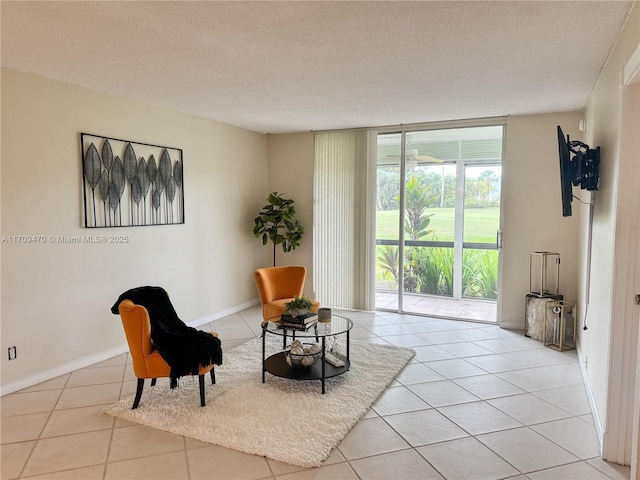 sitting room featuring light tile patterned flooring, a textured ceiling, and expansive windows