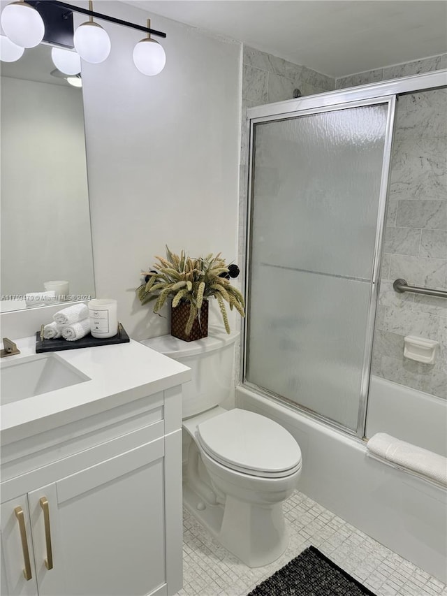 full bathroom featuring toilet, vanity, tile patterned floors, and enclosed tub / shower combo