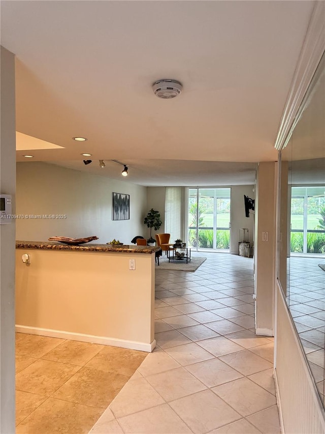 kitchen featuring baseboards, open floor plan, recessed lighting, a peninsula, and light tile patterned flooring