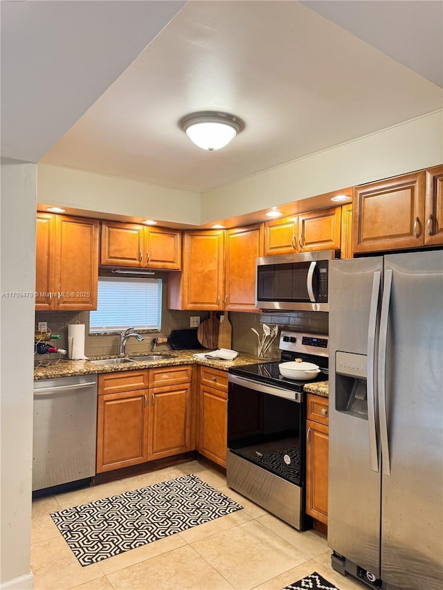 kitchen featuring a sink, tasteful backsplash, brown cabinets, and stainless steel appliances