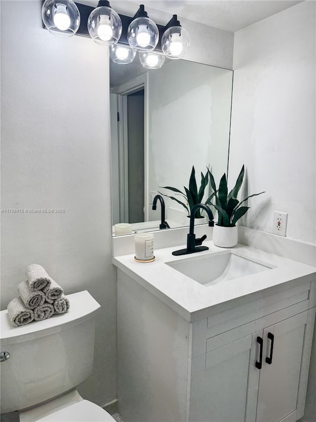 bathroom featuring toilet and vanity