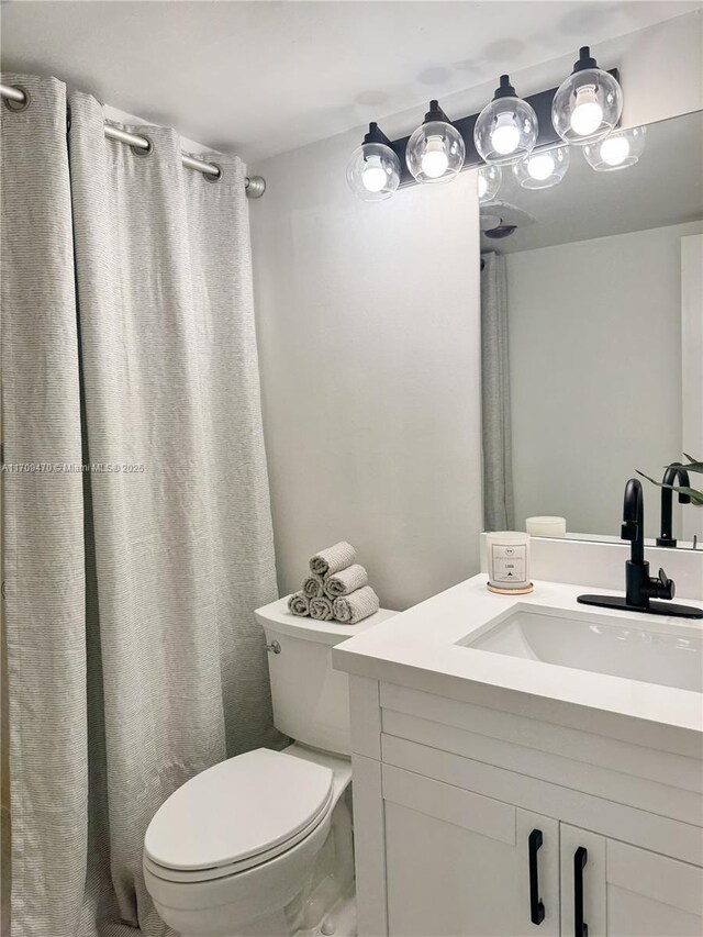 full bath featuring vanity and toilet