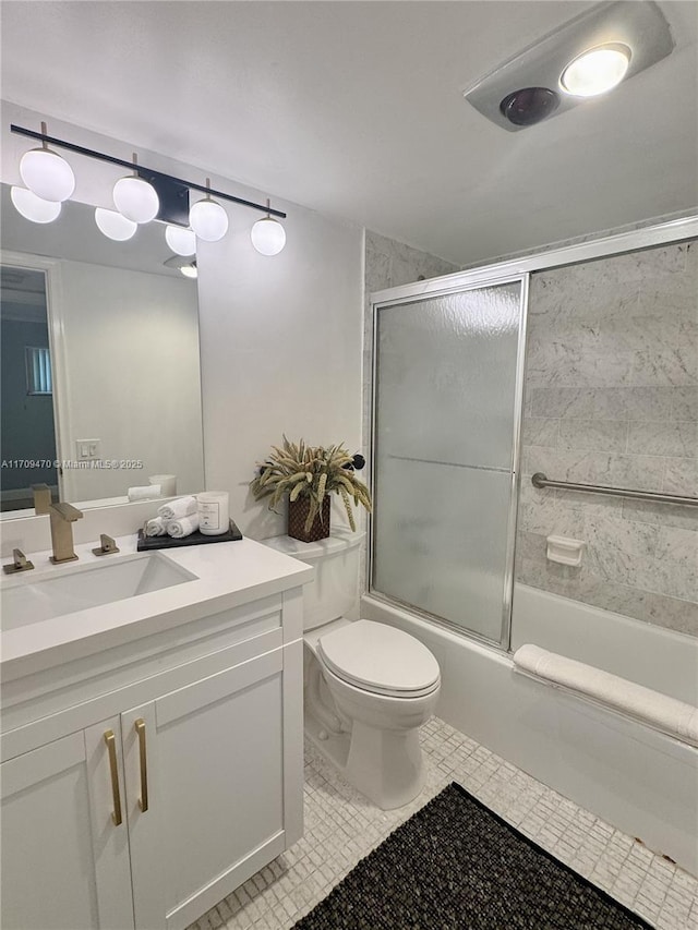 bathroom featuring vanity, toilet, combined bath / shower with glass door, and tile patterned flooring