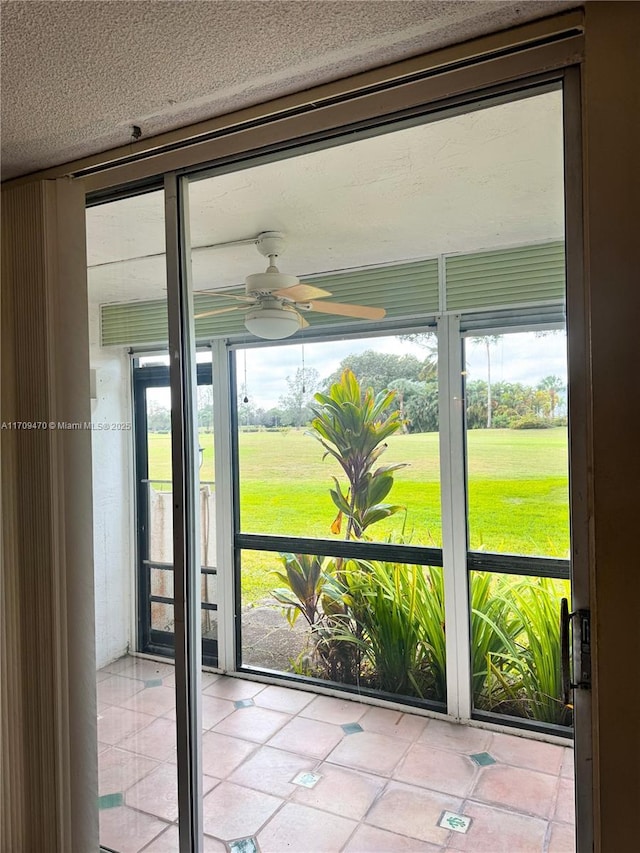 unfurnished sunroom featuring ceiling fan