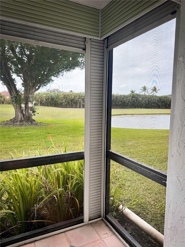 unfurnished sunroom featuring a water view