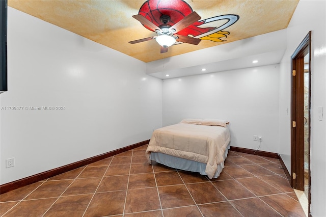 tiled bedroom featuring ceiling fan and a textured ceiling