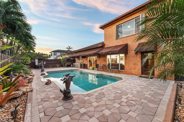 pool at dusk with a patio