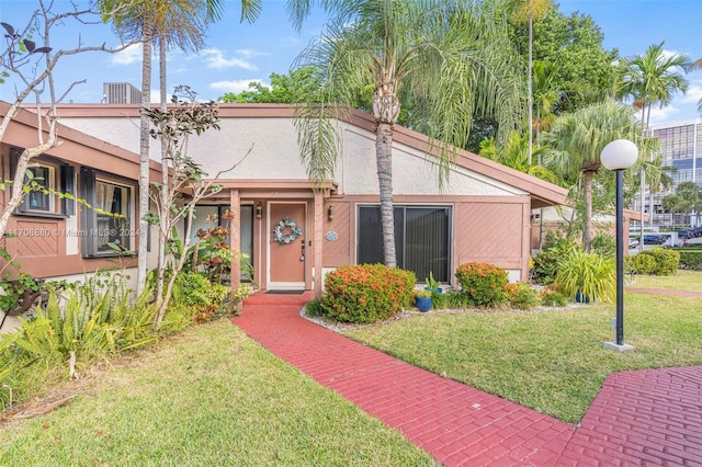 view of front of home featuring a front lawn and central air condition unit