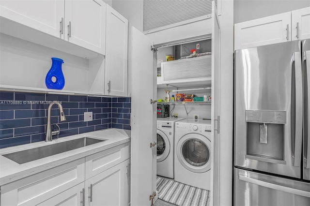 washroom with separate washer and dryer and sink