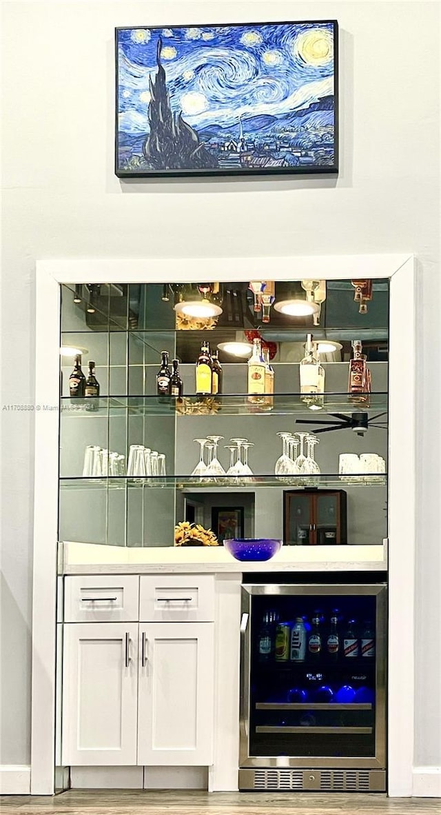 bar with white cabinets, wood-type flooring, and wine cooler