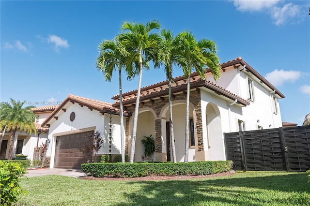 mediterranean / spanish-style house with a garage and a front yard