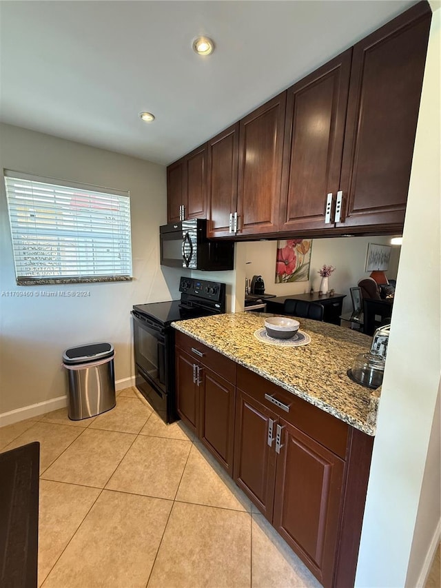 kitchen with light stone countertops, dark brown cabinets, sink, black appliances, and light tile patterned floors