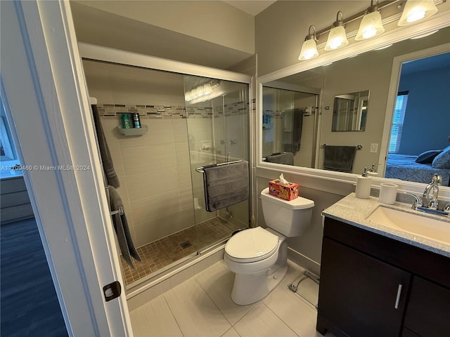 bathroom featuring toilet, vanity, tile patterned floors, and walk in shower