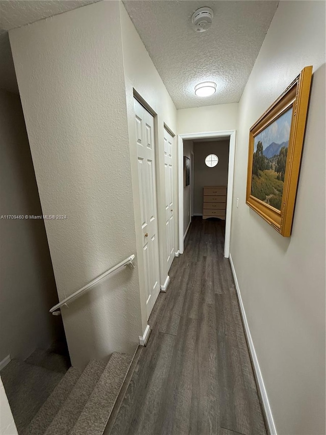 hall featuring dark hardwood / wood-style floors and a textured ceiling