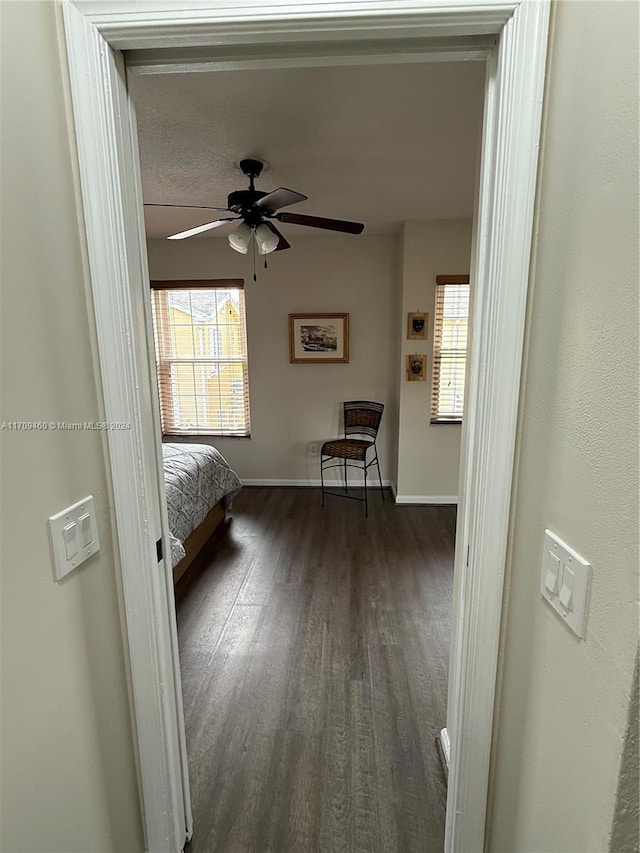 unfurnished bedroom with ceiling fan and dark wood-type flooring