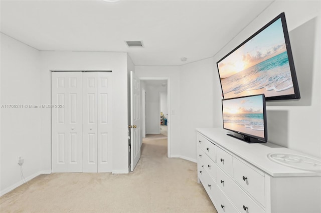 unfurnished bedroom featuring light colored carpet and a closet