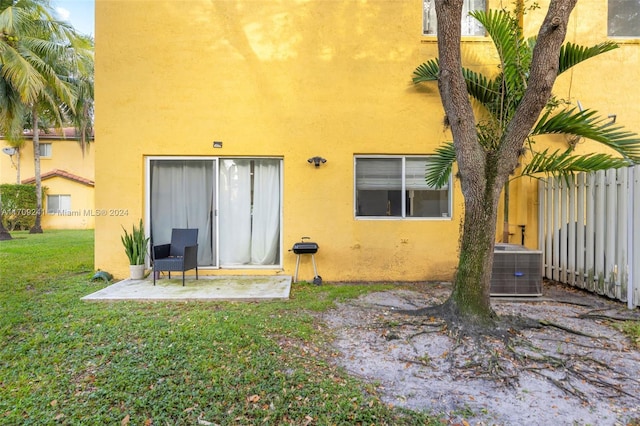 back of property with a lawn and cooling unit