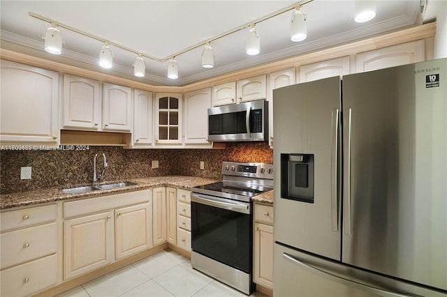 kitchen featuring appliances with stainless steel finishes, backsplash, dark stone counters, crown molding, and sink